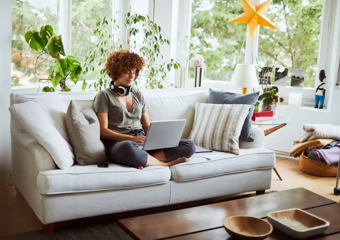 Woman sitting on couch looking at a laptop