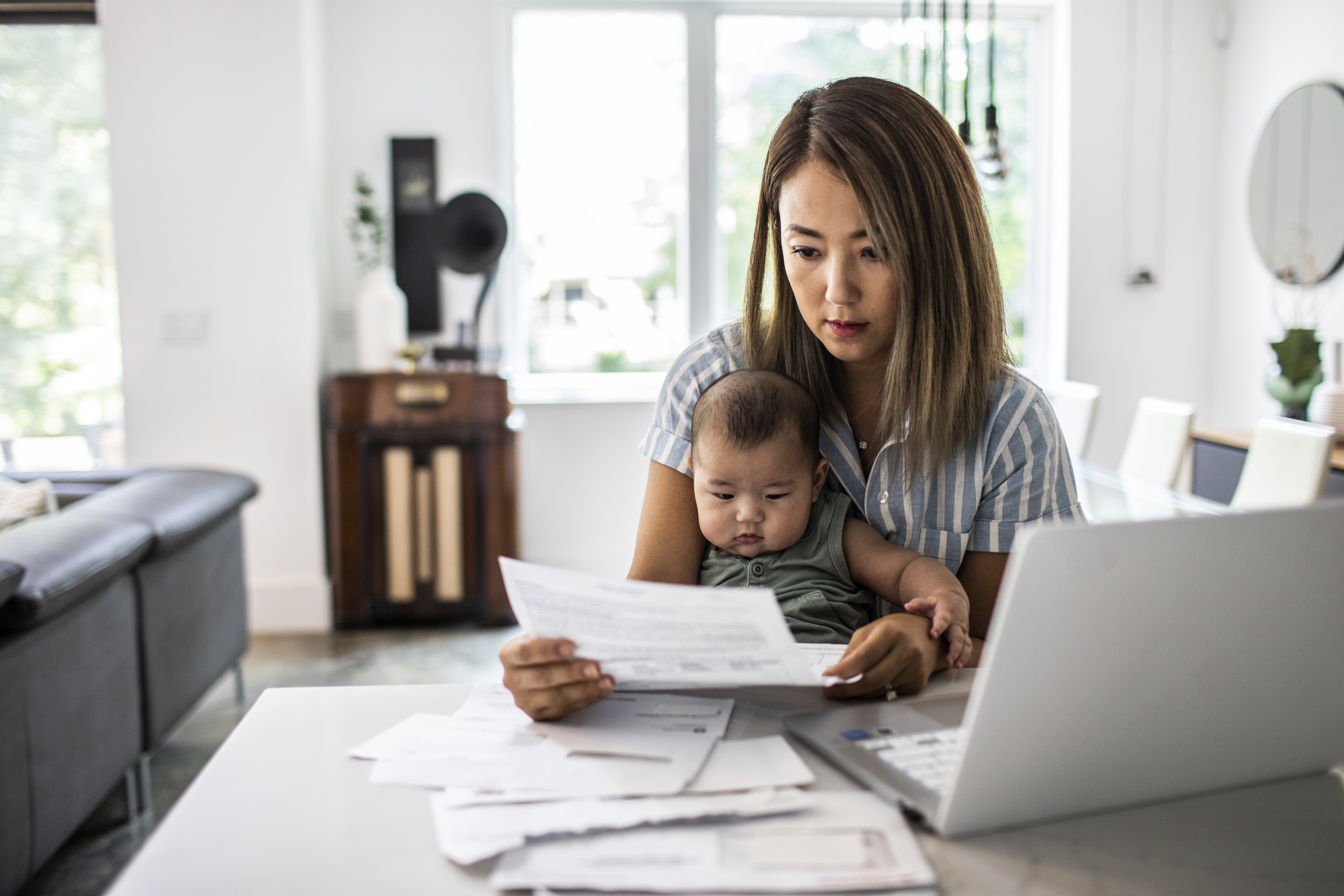 Mother working from home while holding baby