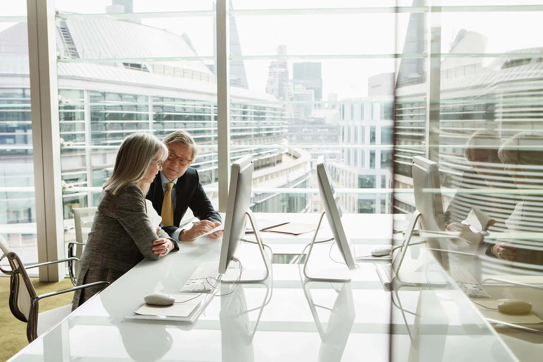 Two employees having a discussion in a conference room.