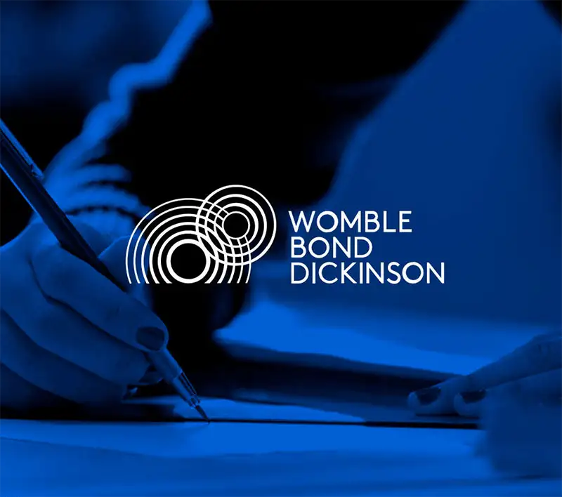 Womble Bond Dickenson logo over an image of someone signing a document