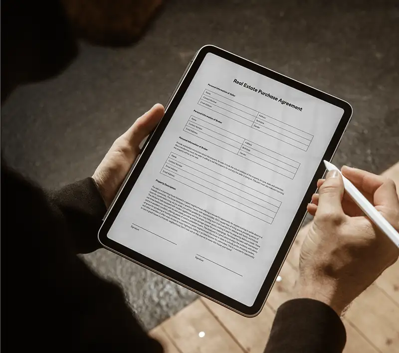 A real estate purchase agreement that a person is filling out on a tablet with DocuSign eSignature.